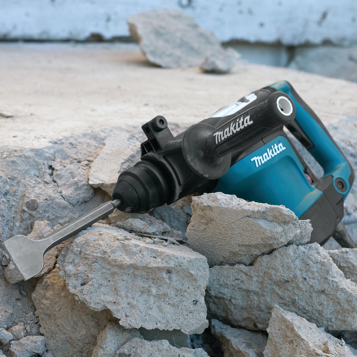 Makita 2" x 8.5" scaling chisel SDS+ in use at active jobsite removing tile from concrete