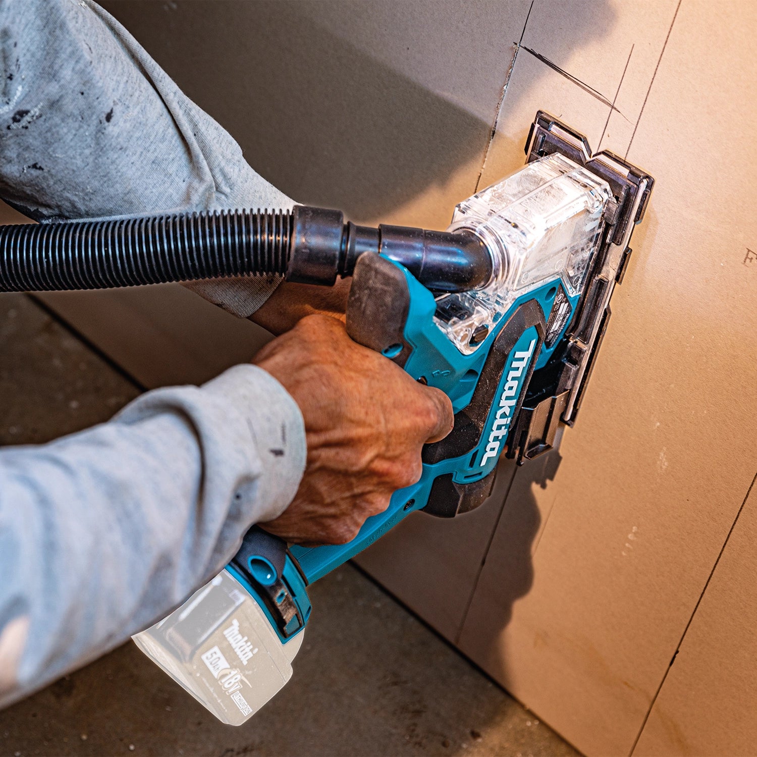 Makita drywall saw cutting vertically into interior wall