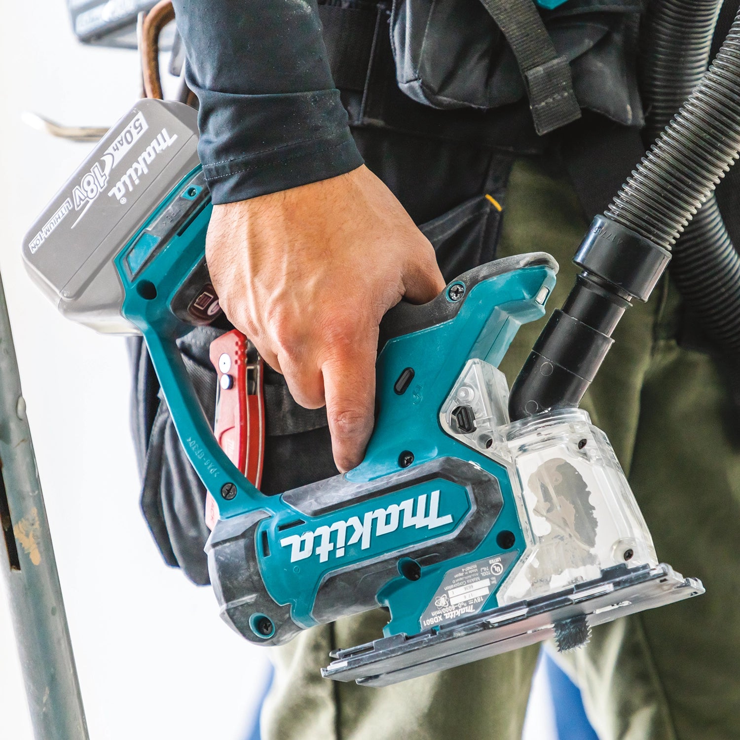 Operator holding Makita drywall saw on jobsite