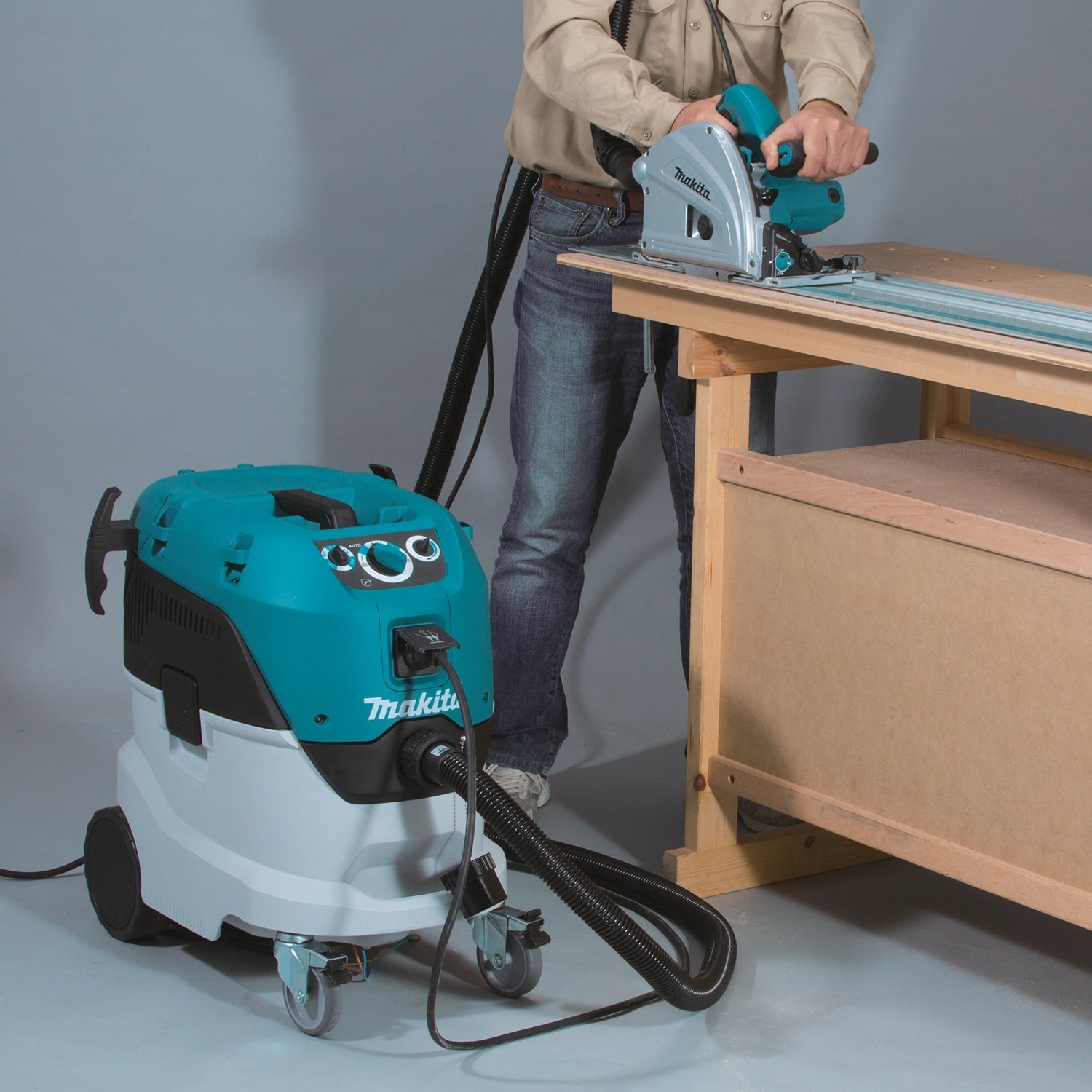 Makita VC4210L vacuum connected to circular saw during wood cutting on a jobsite