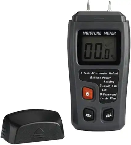 digital moisture meter with exposed sensor pins and detached cap for restoration use