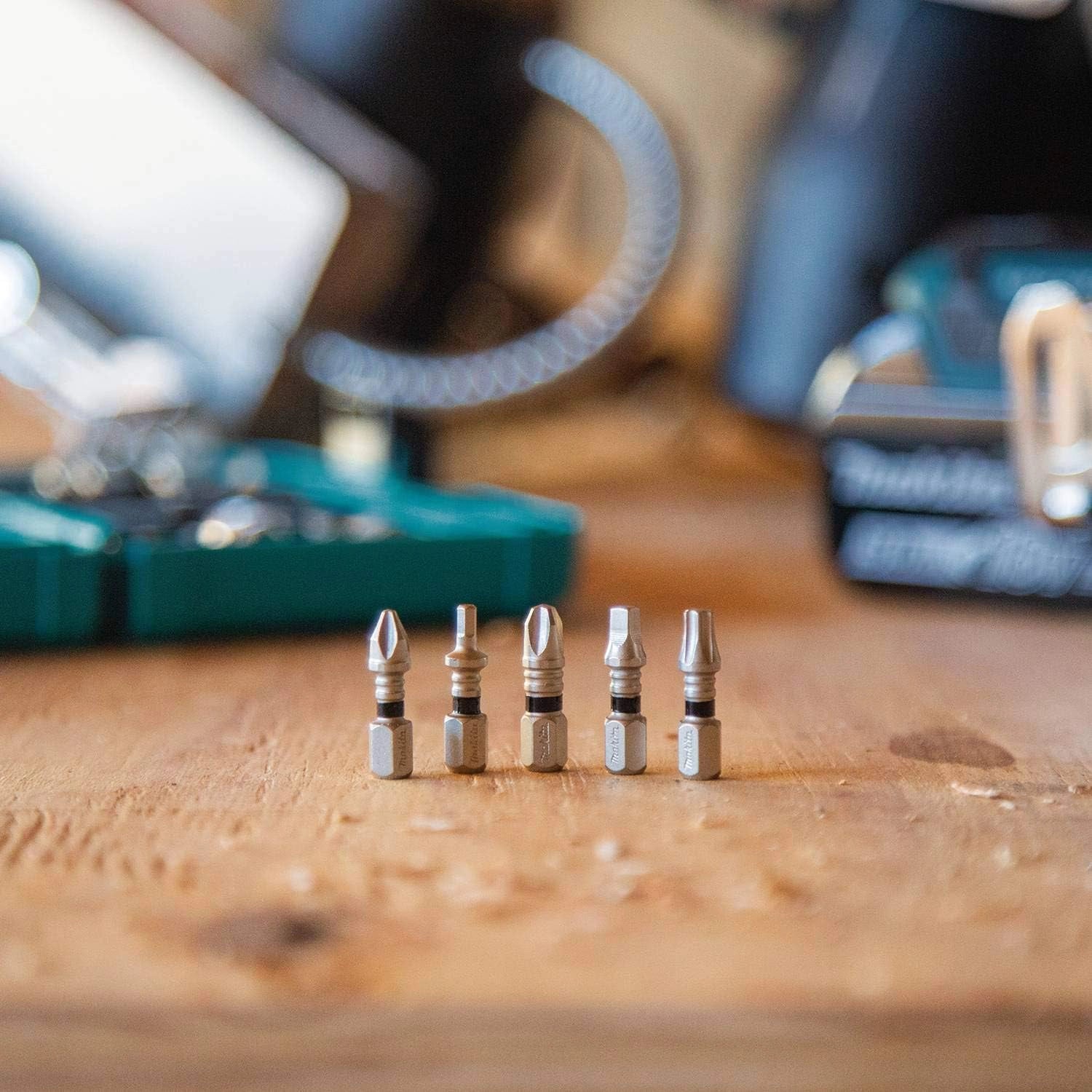 multiple makita phillips bits stacked vertically on jobsite surface