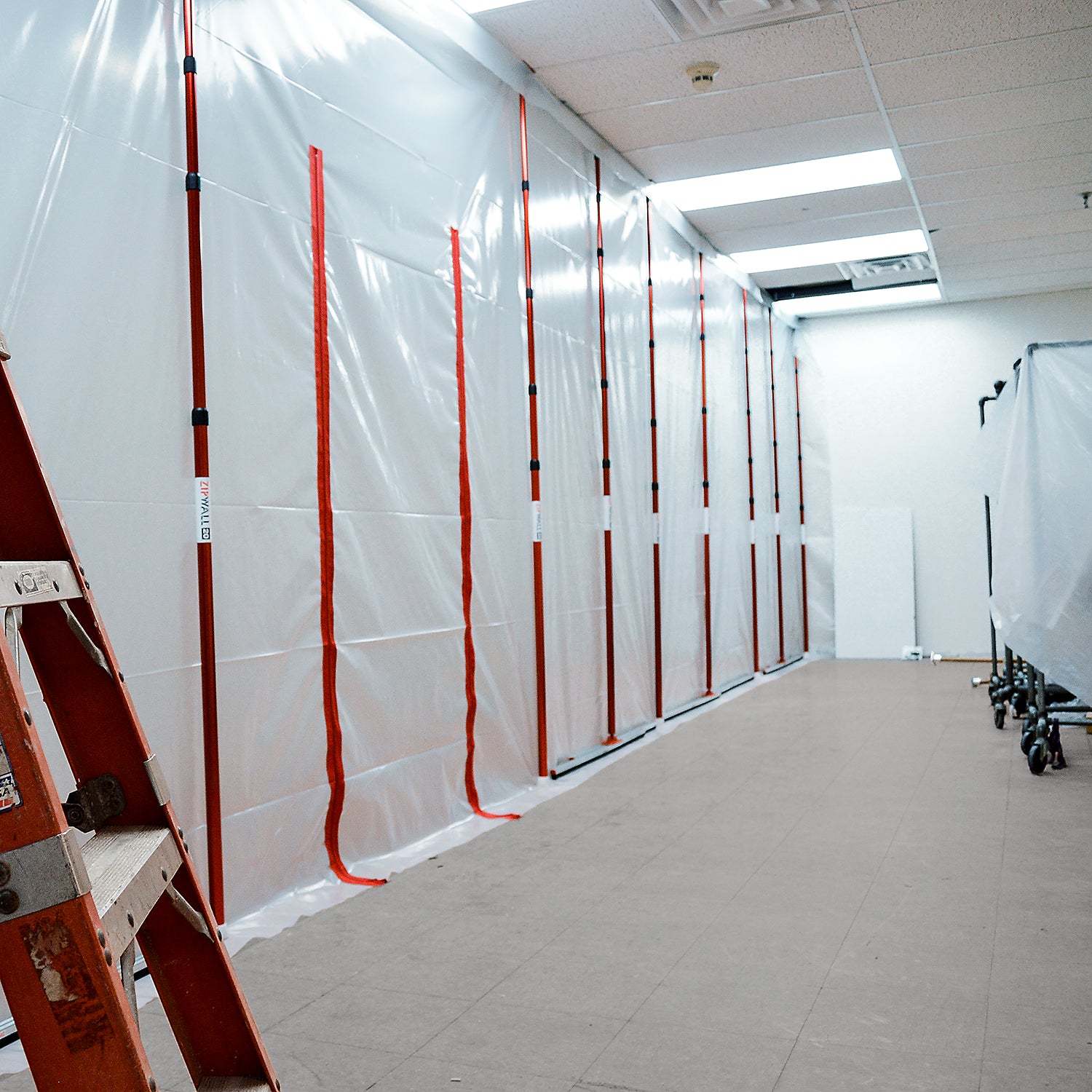 ZipWall 20-foot poles set up in hallway for tall ceiling dust control
