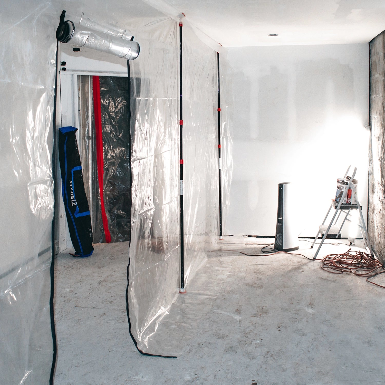 ZipWall poles installed in residential room for dust containment setup