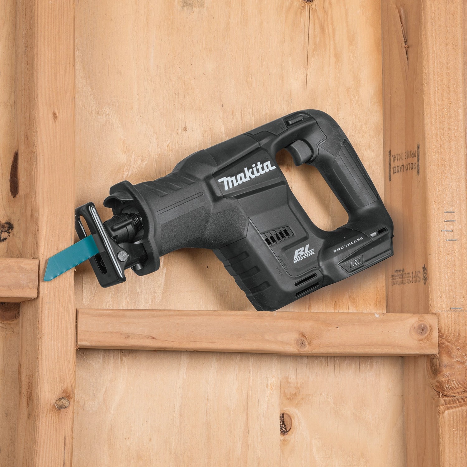 angled view of makita compact recipro saw on job site cutting into framing
