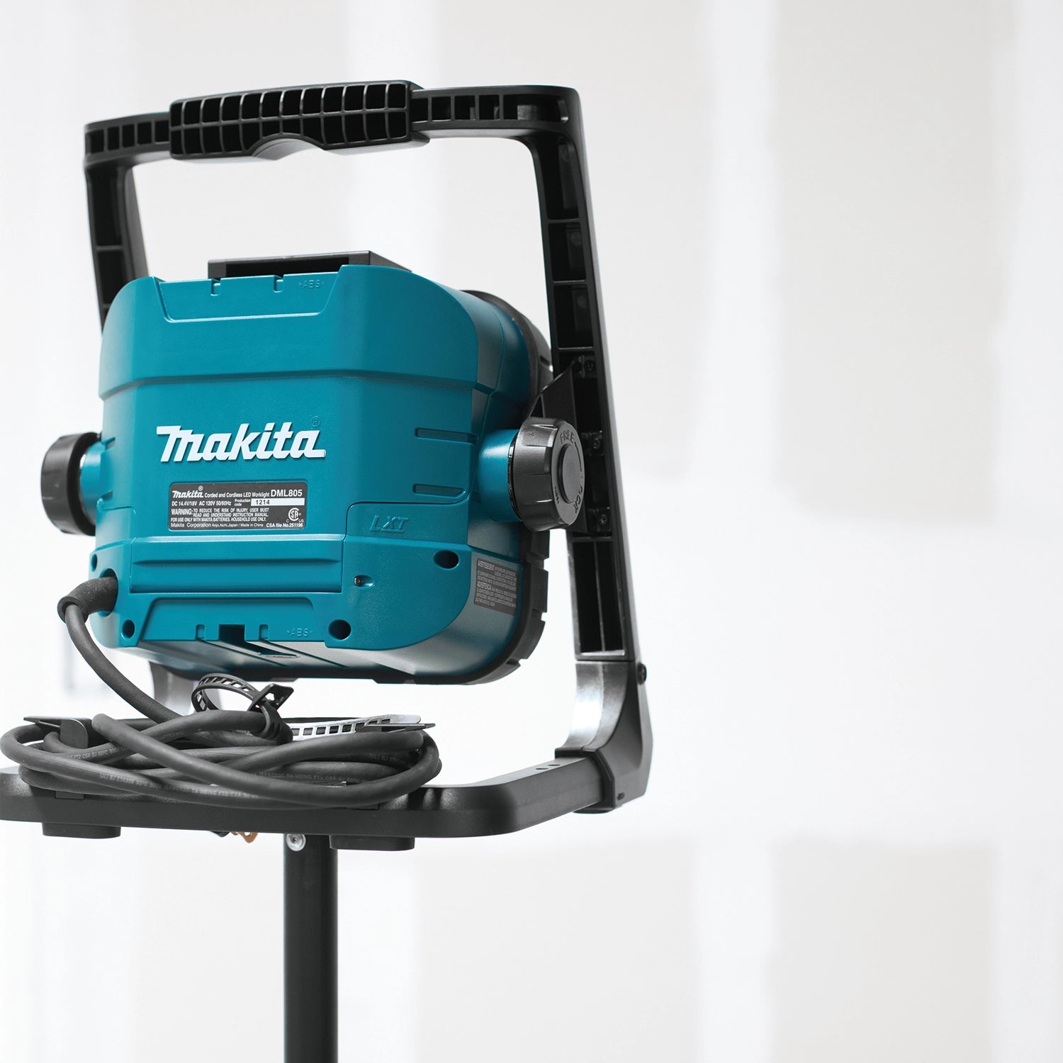 rear view of makita led work light on stand with visible cord input and battery slot
