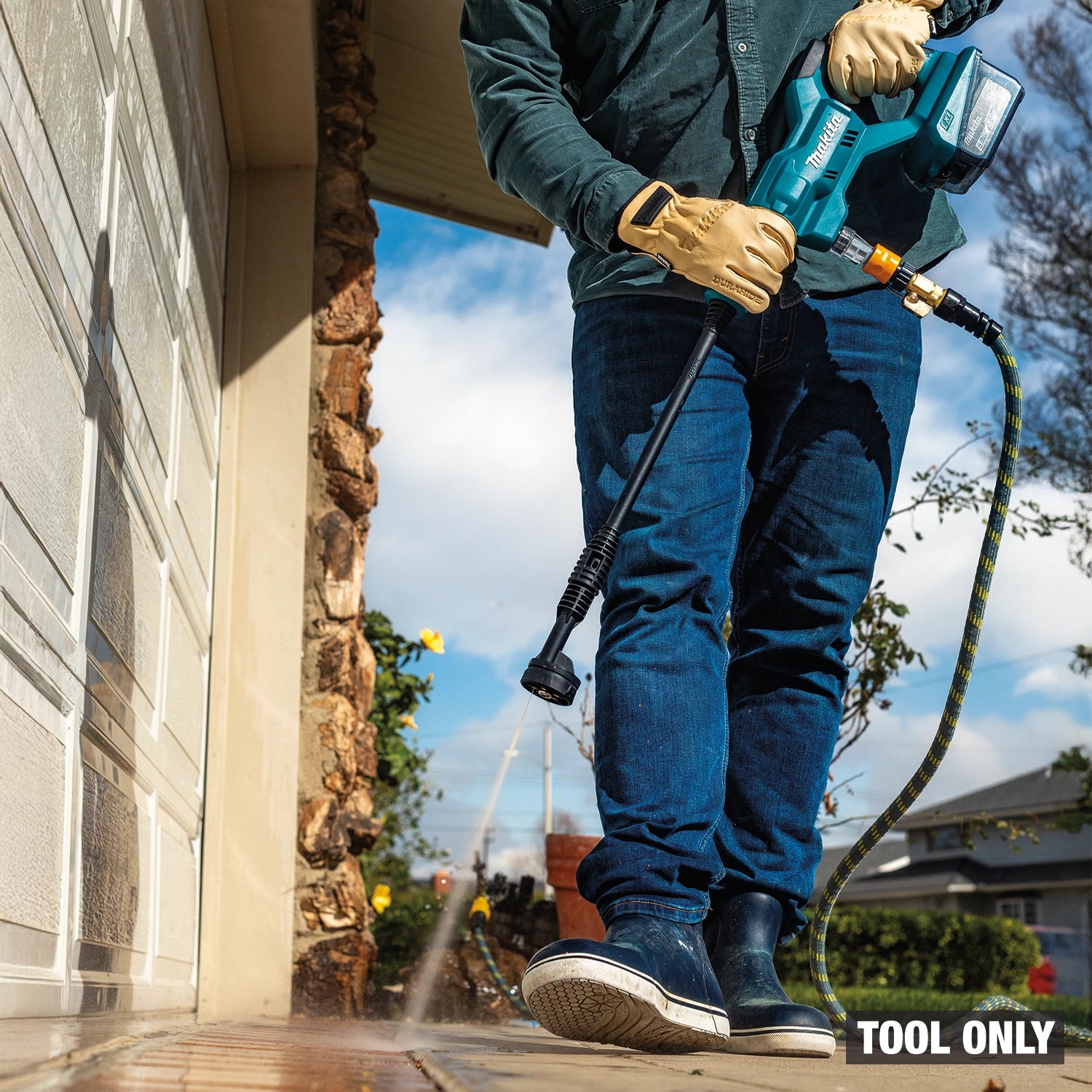 Person using a pressure washer tool on a house exterior
