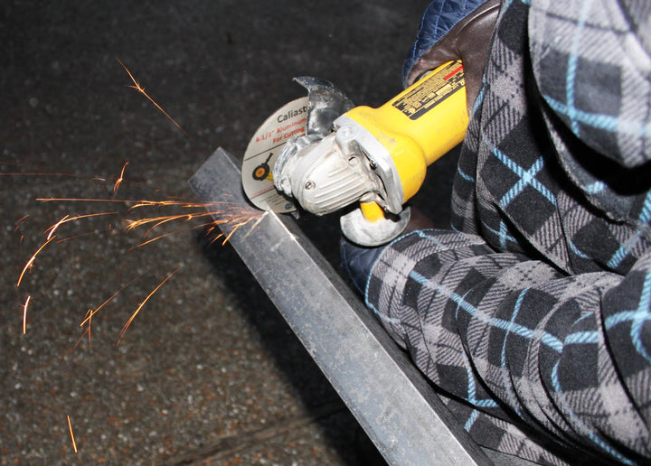 Caliastro cut out wheel in use on angle grinder cutting through metal pipe
