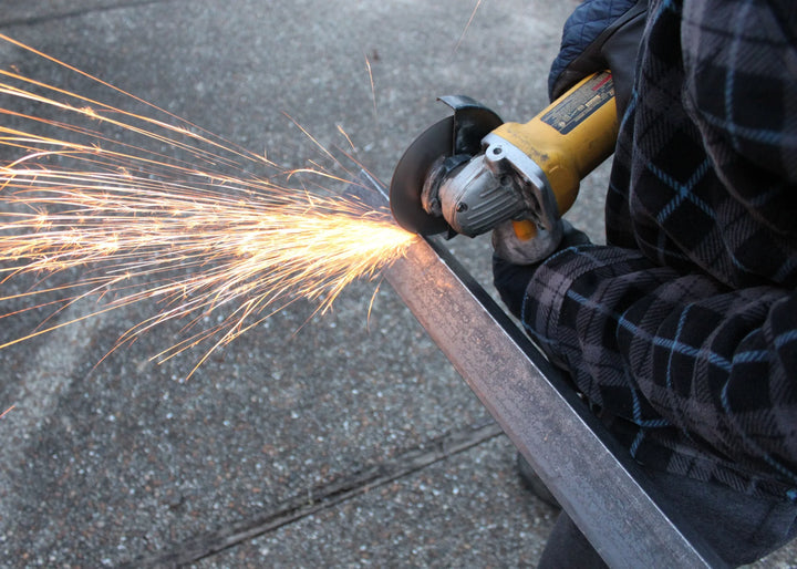 Worker using Caliastro 4.5-inch wheel to cut stainless steel tubing on jobsite
