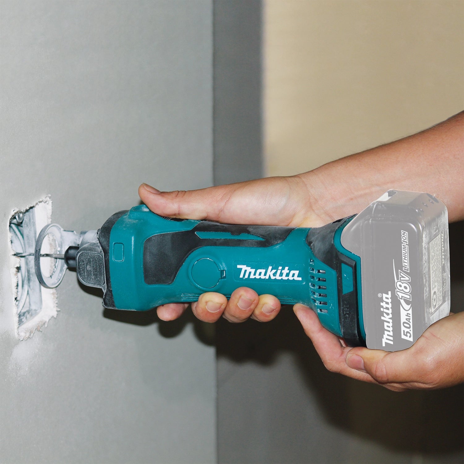 makita cordless cut-out tool cutting drywall with precision and speed

