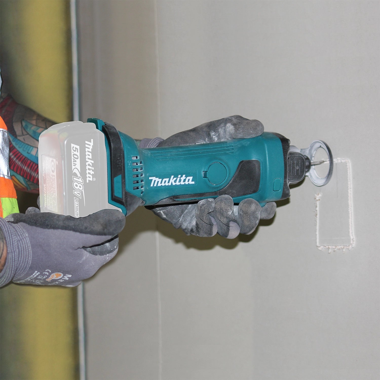 cutting electrical outlet opening in drywall with makita cordless cut-out tool
