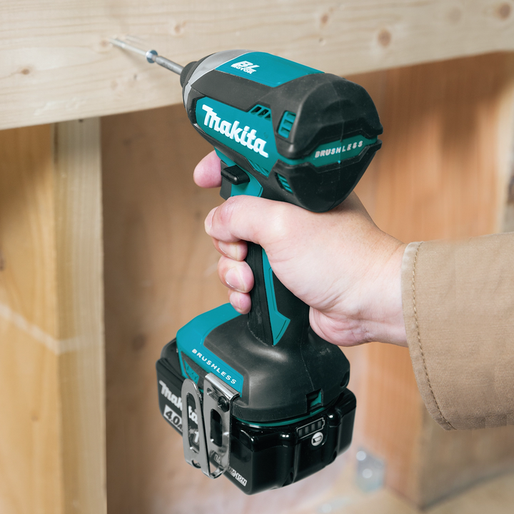 worker using makita hammer drill to drill into ceiling for overhead installation
