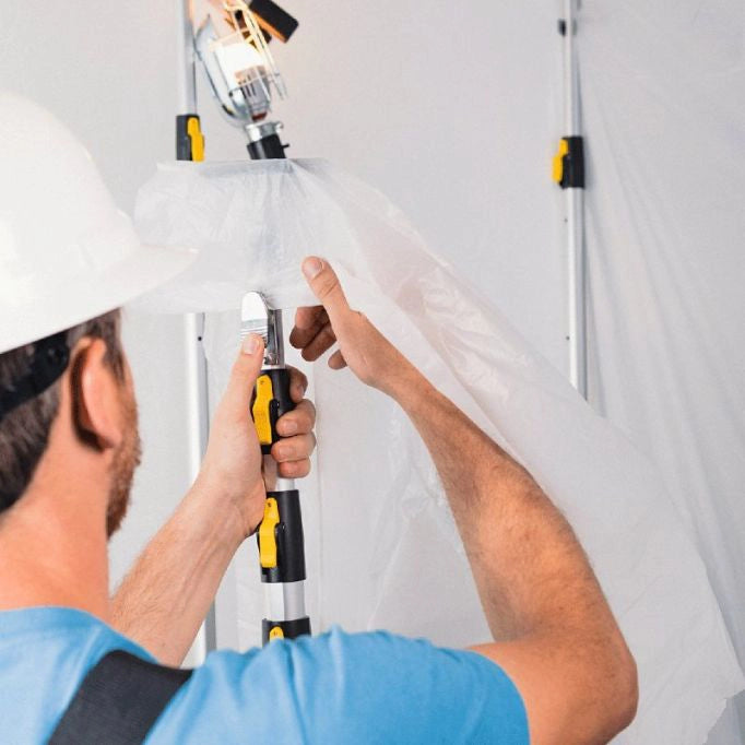 Plastic sheeting being pushed upward and clipped into E-Z UP containment pole

