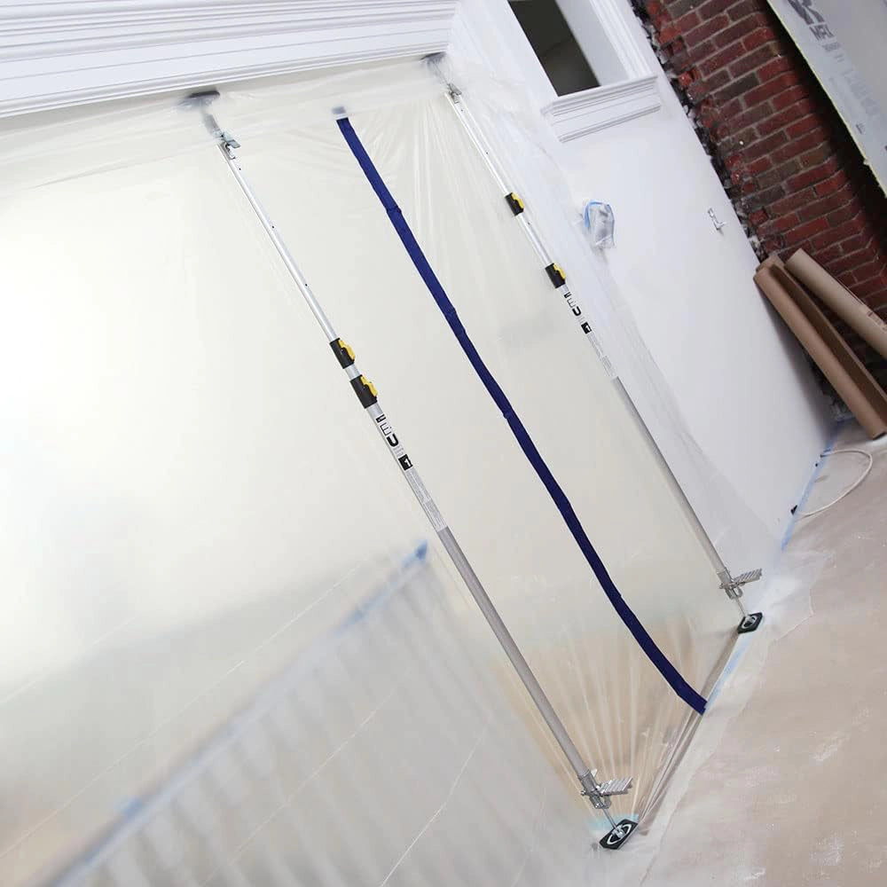 E-Z UP 20-foot pole in use holding up large plastic sheet during jobsite prep
