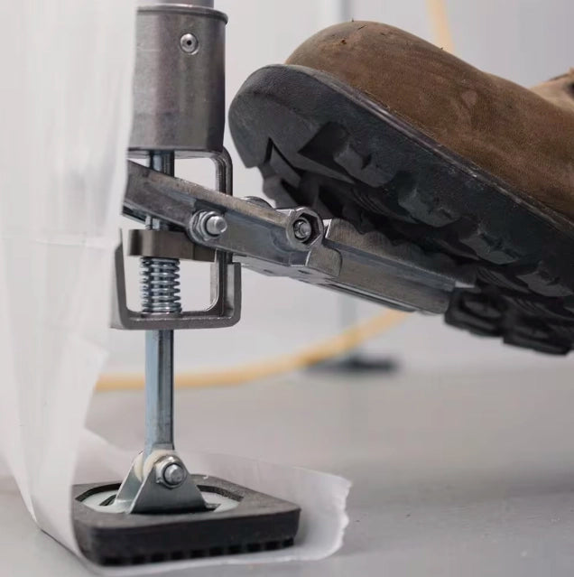 Worker pushing foot pedal on E-Z UP 20-foot pole to adjust height securely
