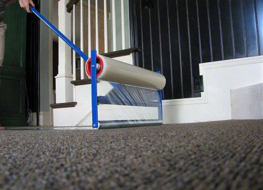 Ground-level view of film being applied to carpet using Trimaco Applicator
