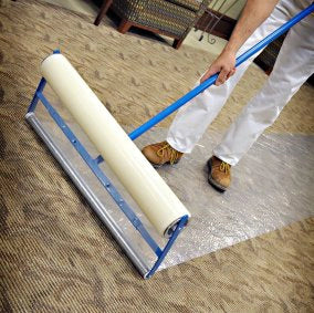 Worker applying protective film to floor using Trimaco Applicator
