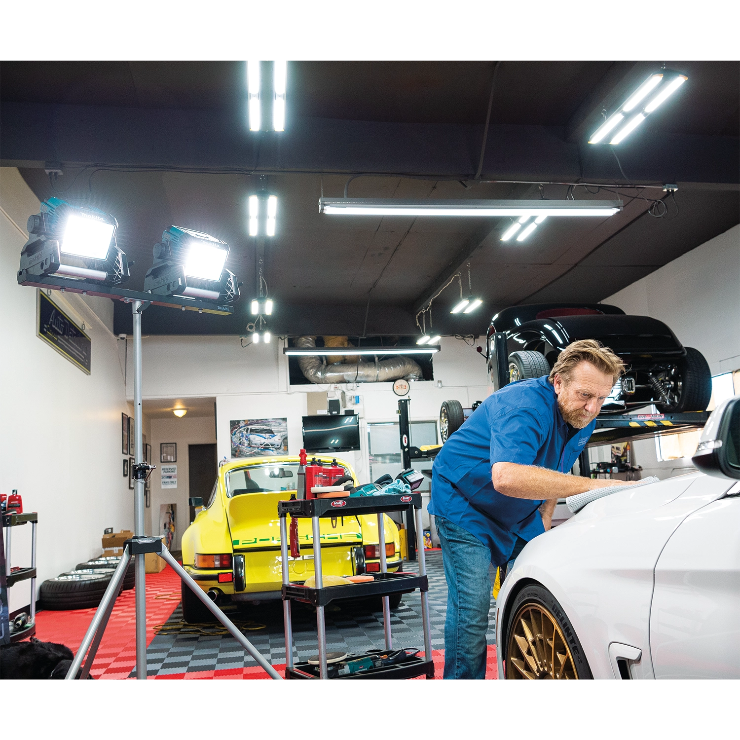 makita dml811 led work light set up in car shop during late shift operations
