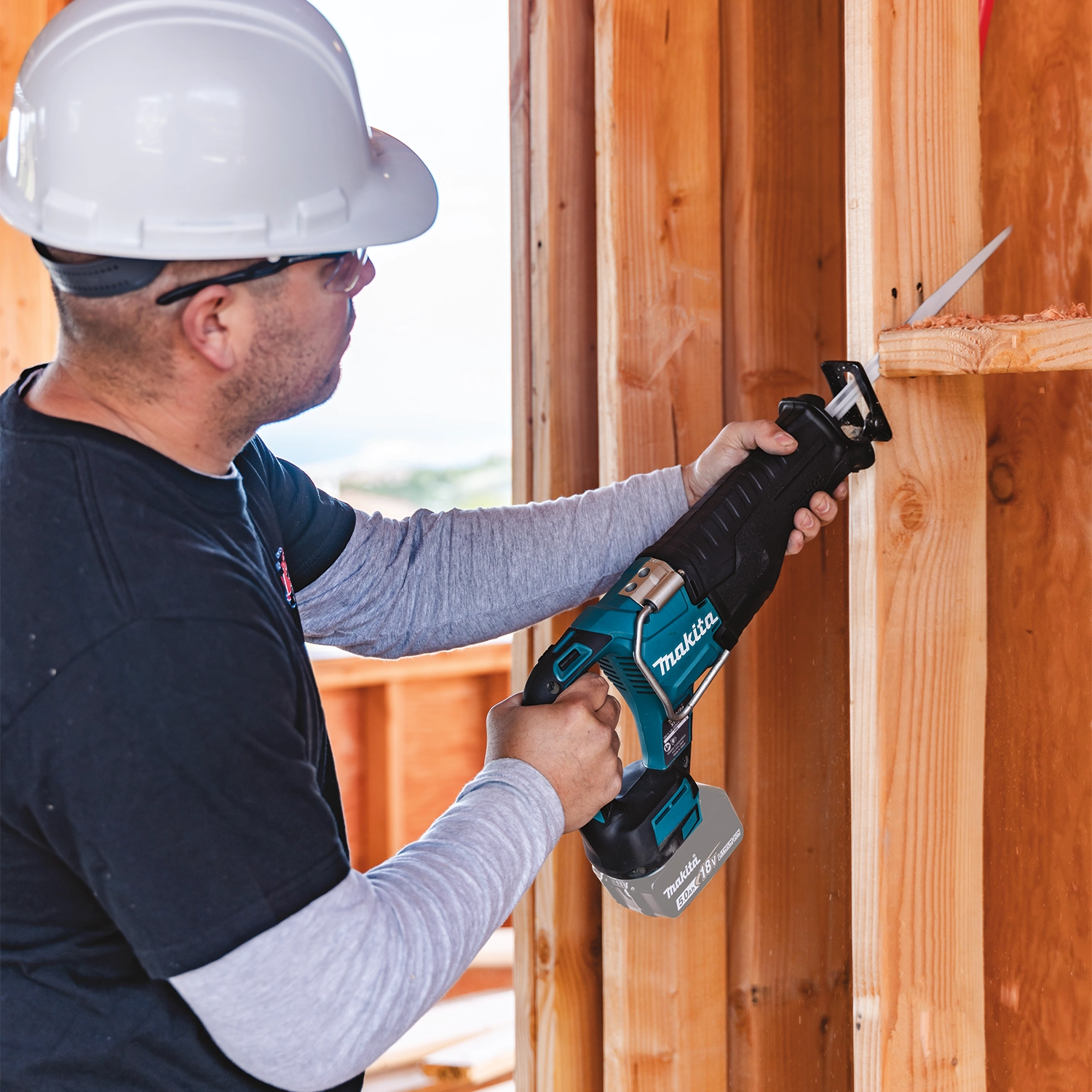 makita 18v lxt reciprocating saw in use cutting wood on construction site
