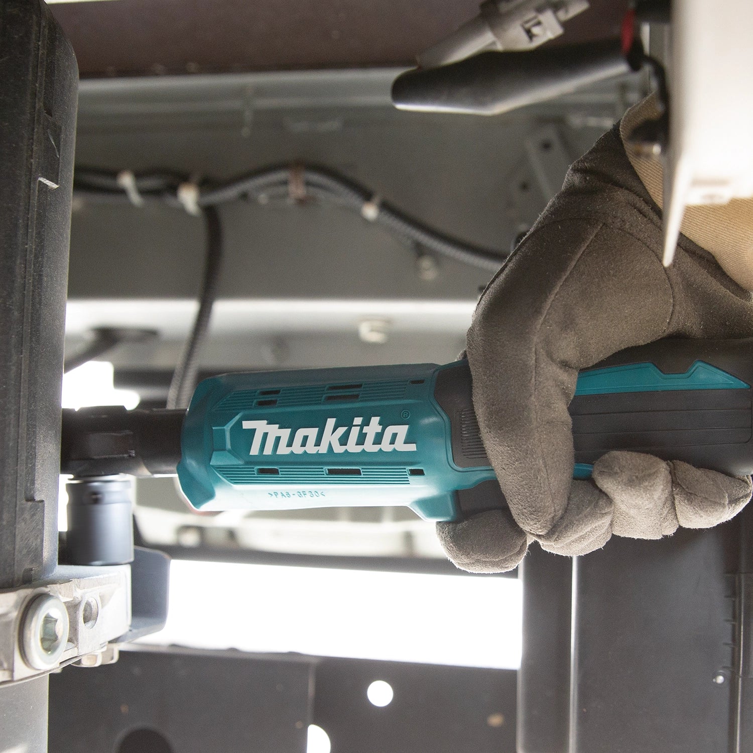 operator using makita 18v cordless ratchet for automotive fastening task
