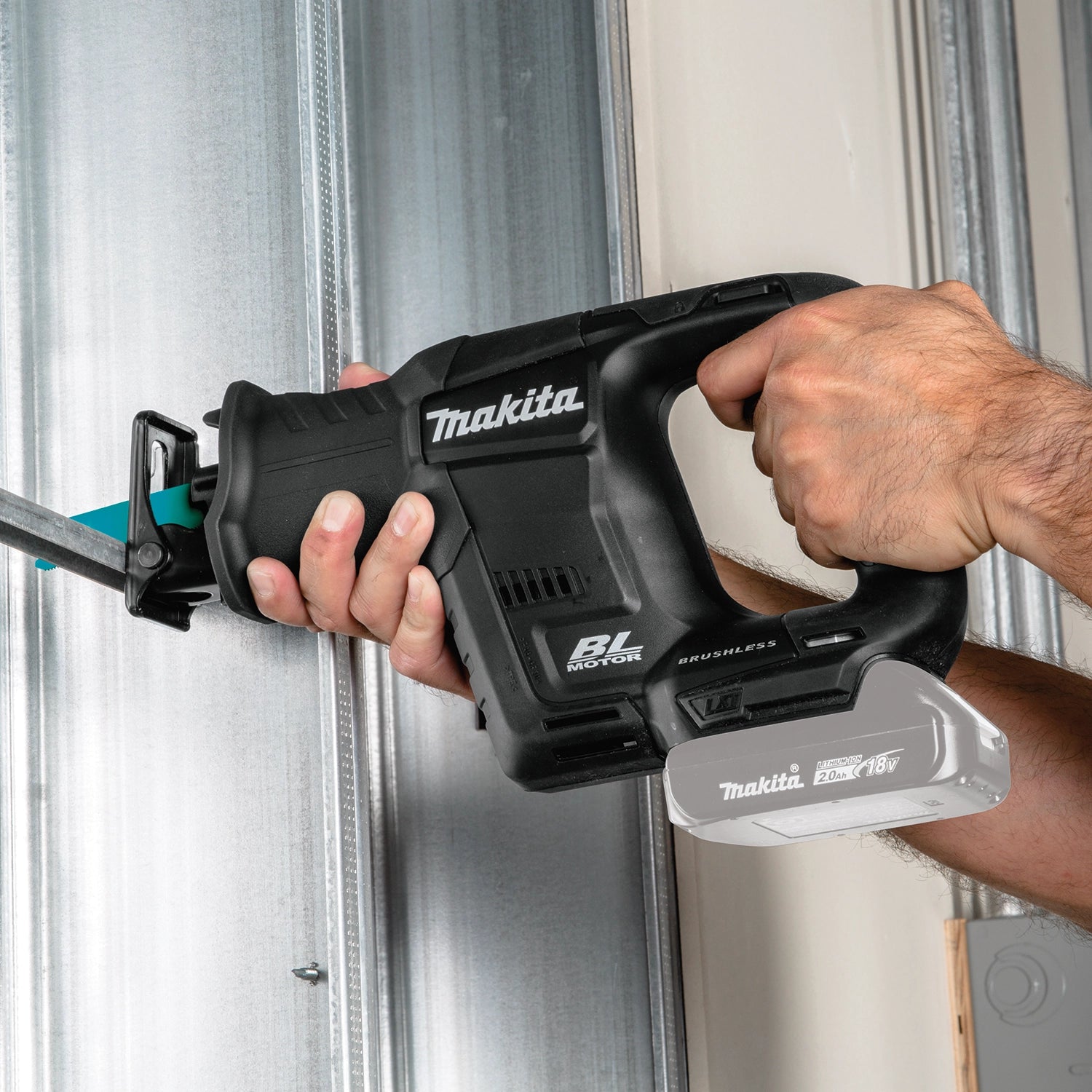 makita 18v compact recipro saw in use cutting through drywall on job site
