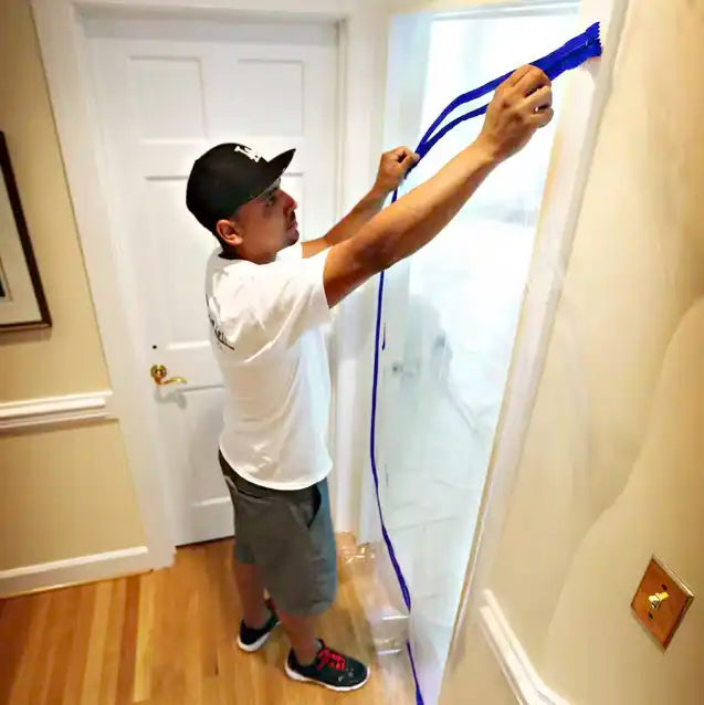 Installer applying E-Z Up zipper to a plastic containment doorway
