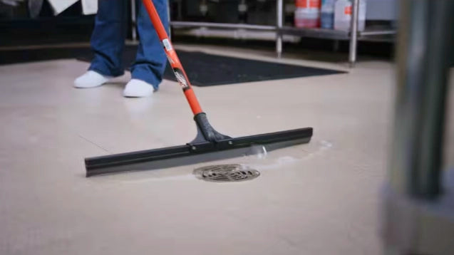 Libman floor squeegee being used on job site for water cleanup
