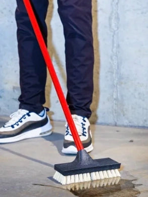 Libman Acid Brush in use scrubbing floor surface with cleaning solution
