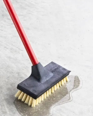 Libman brush pushing water during industrial floor cleaning

