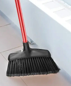 Worker using Libman Angle Broom on a commercial job site floor
