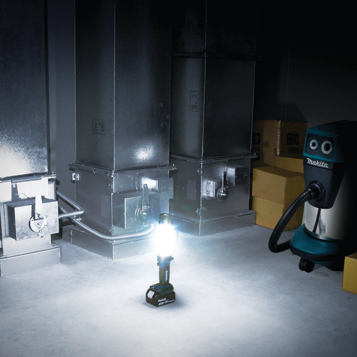 makita lantern flashlight with light on in dark jobsite environment
