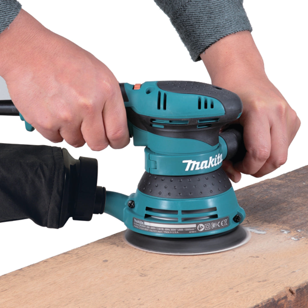 makita bo5041 sander in use sanding wooden board during fine finishing task
