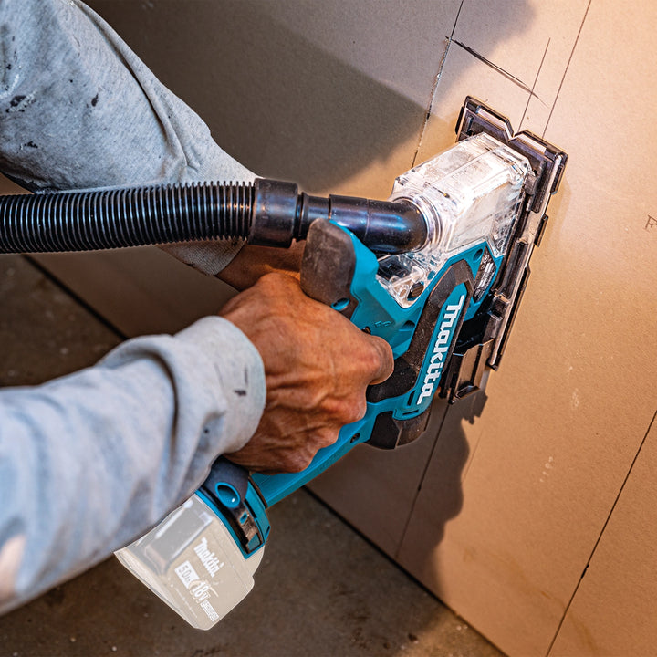 Makita drywall saw cutting vertically into interior wall
