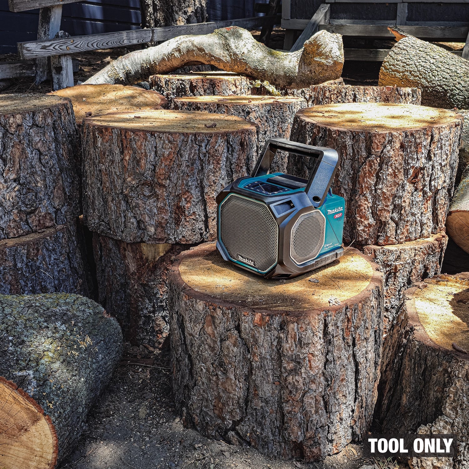 Makita GRM05 angled view on stack of logs at outdoor jobsite
