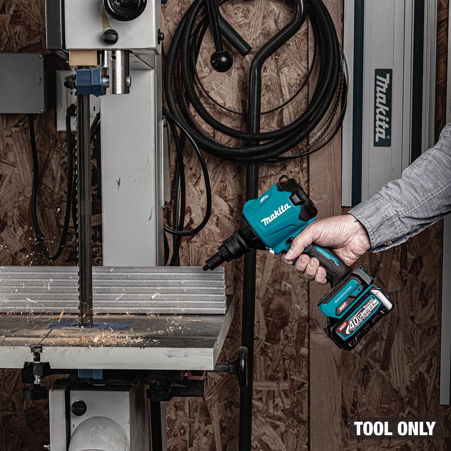 Worker using Makita GSA01Z blower in barn workspace
