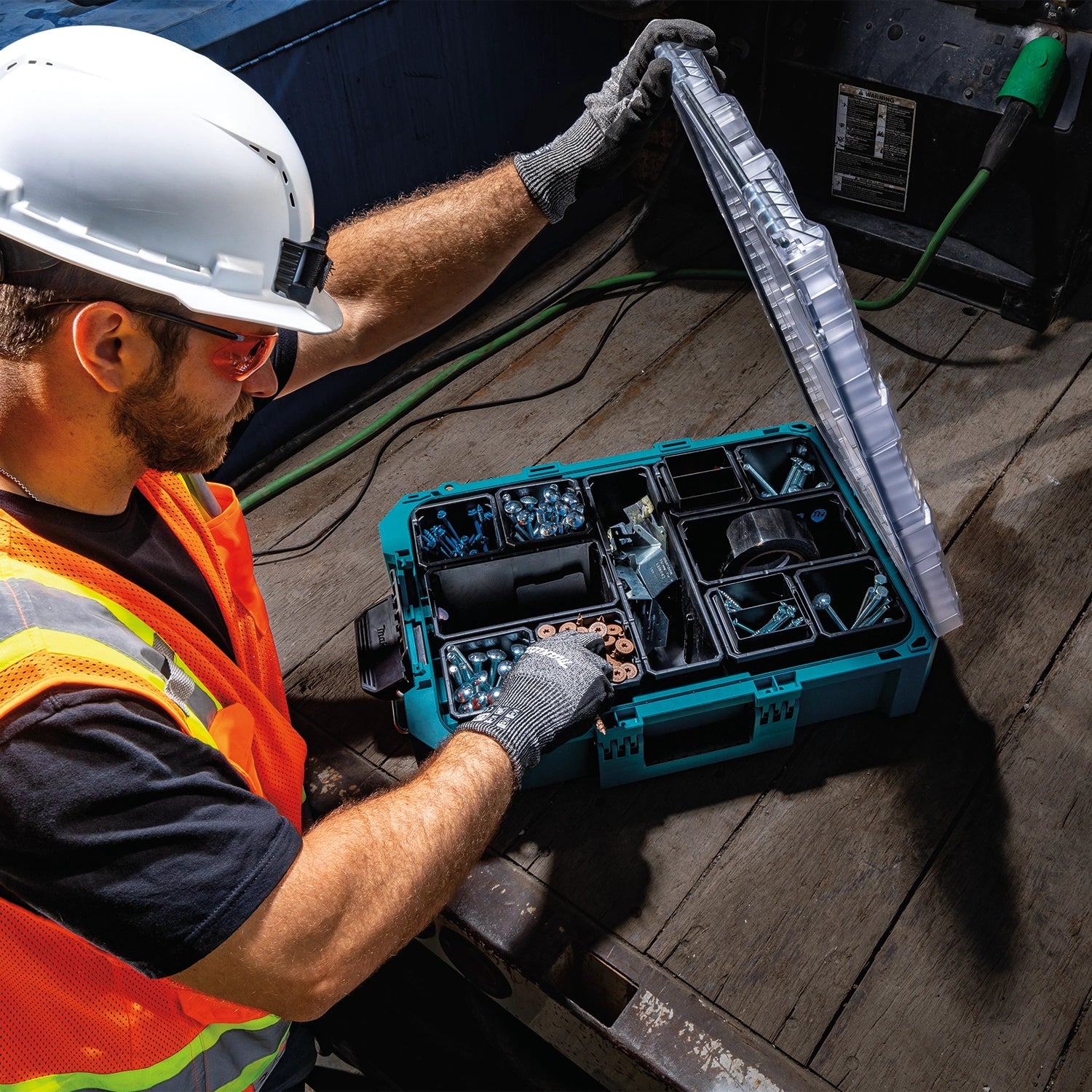 Worker pulling part from open Makita T-90043 container

