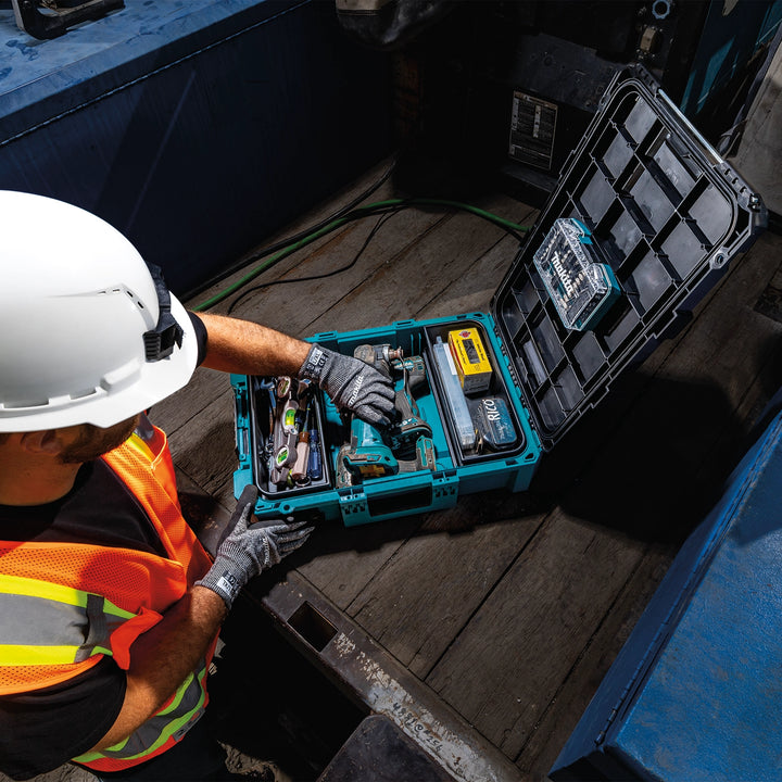Worker organizing Makita T-90037 tool box on truck bed
