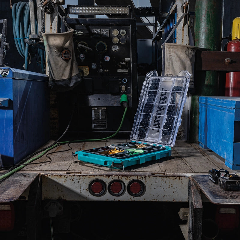 Makita T-90059 MAKTRAK™ Low Profile Organizer open on a service truck bed, displaying assorted fasteners and parts.

