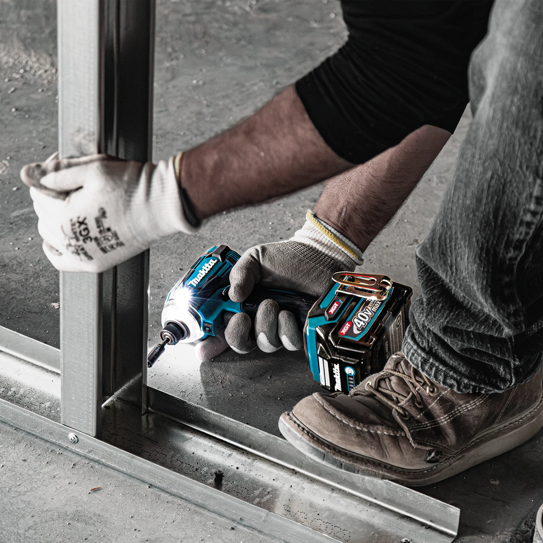 makita drill and impact driver resting on beam during job site break
