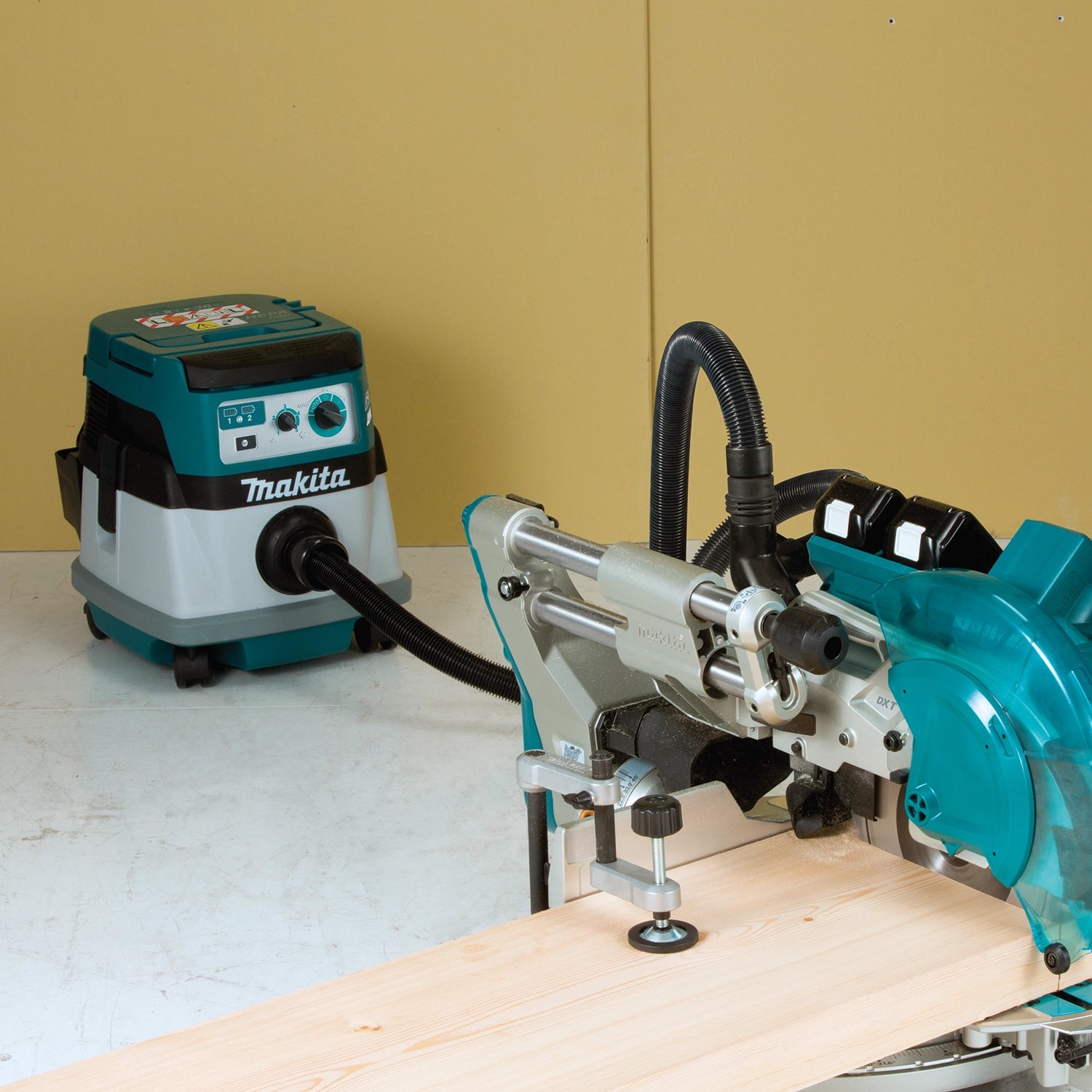 makita xcv22ptu vacuum in use on construction site with power tools connected
