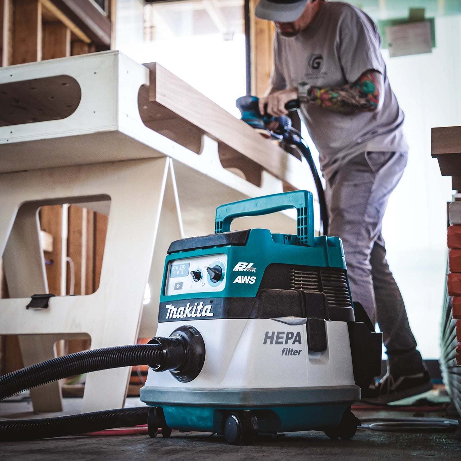makita vacuum on job site connected to table saw collecting airborne debris
