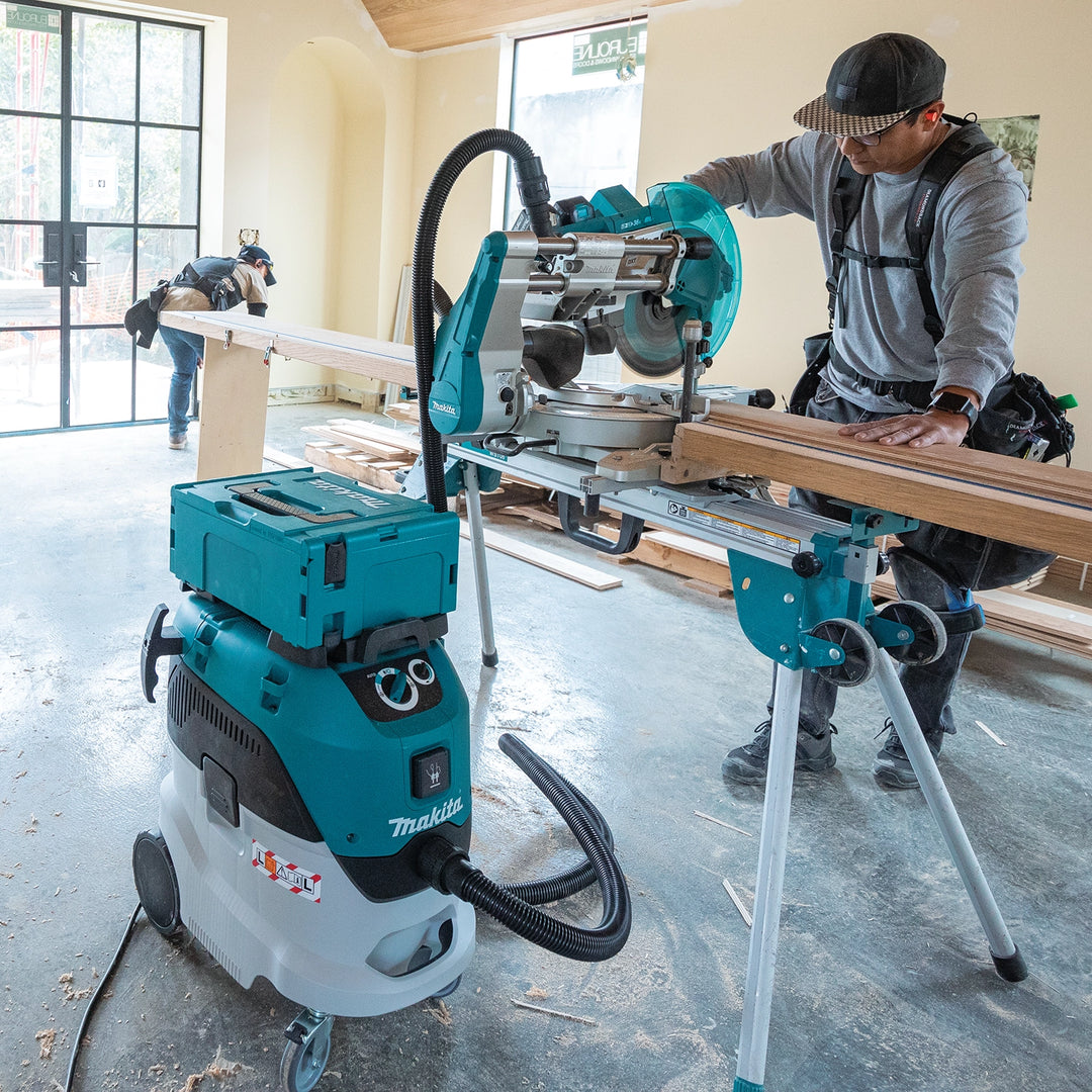 Contractor using a Makita miter saw connected to Makita VC4210L dust extractor on a residential jobsite

