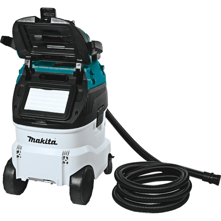 Makita VC4210L dust extractor with open filter compartment and coiled hose on the ground

