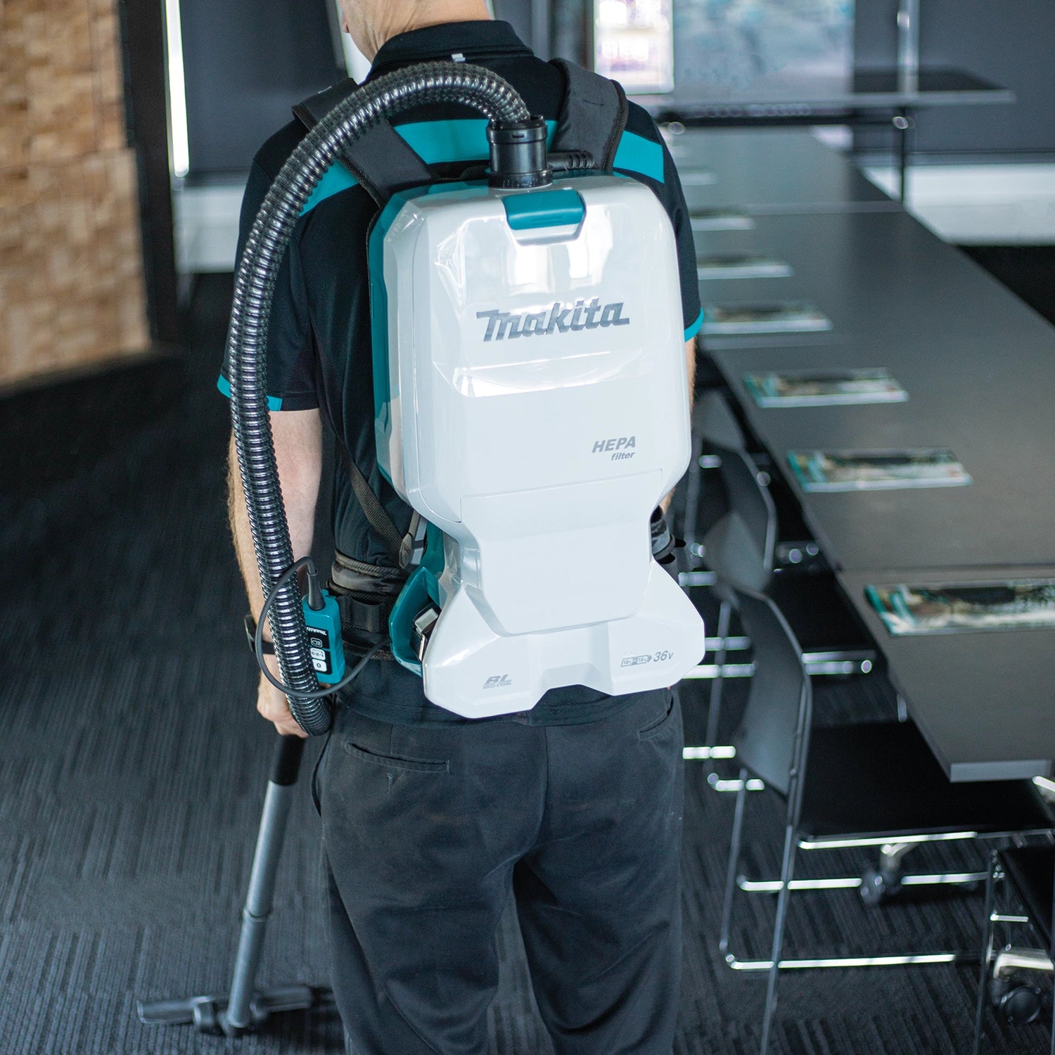makita hepa backpack vacuum worn by worker cleaning woodshop sawdust

