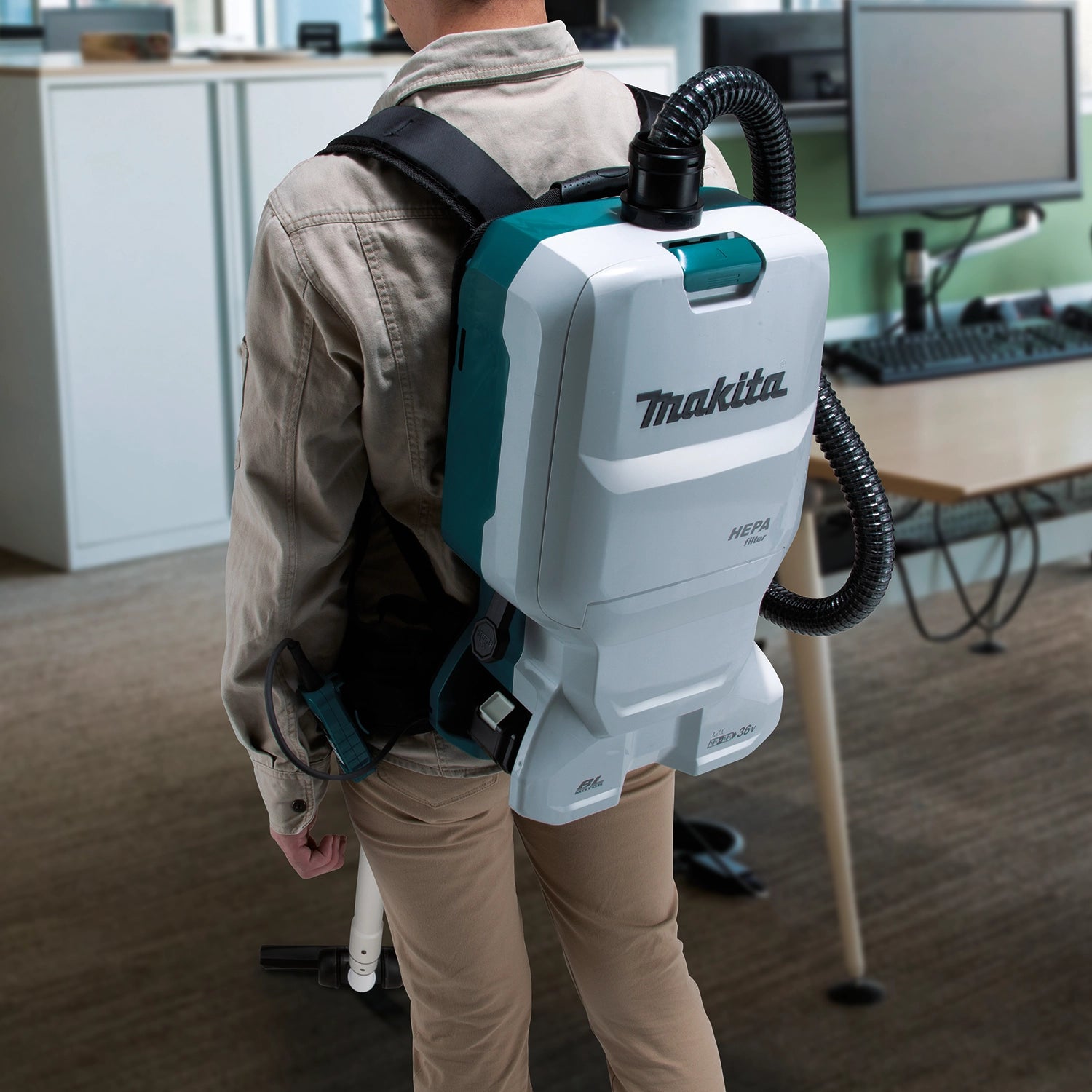 makita 36v backpack vacuum used in hallway cleaning application with long hose
