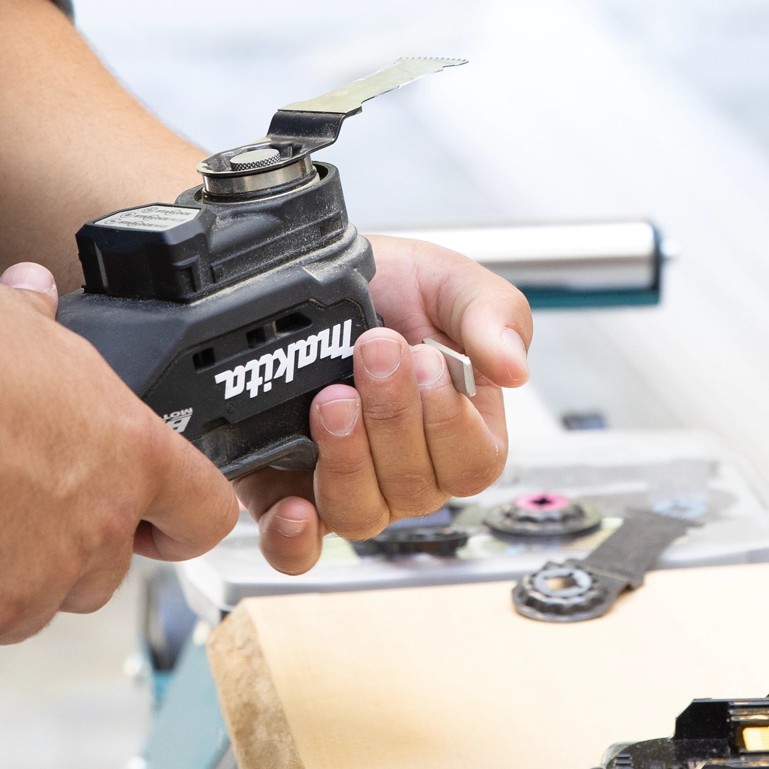 User preparing Makita XMT04ZB multi-tool for use on jobsite
