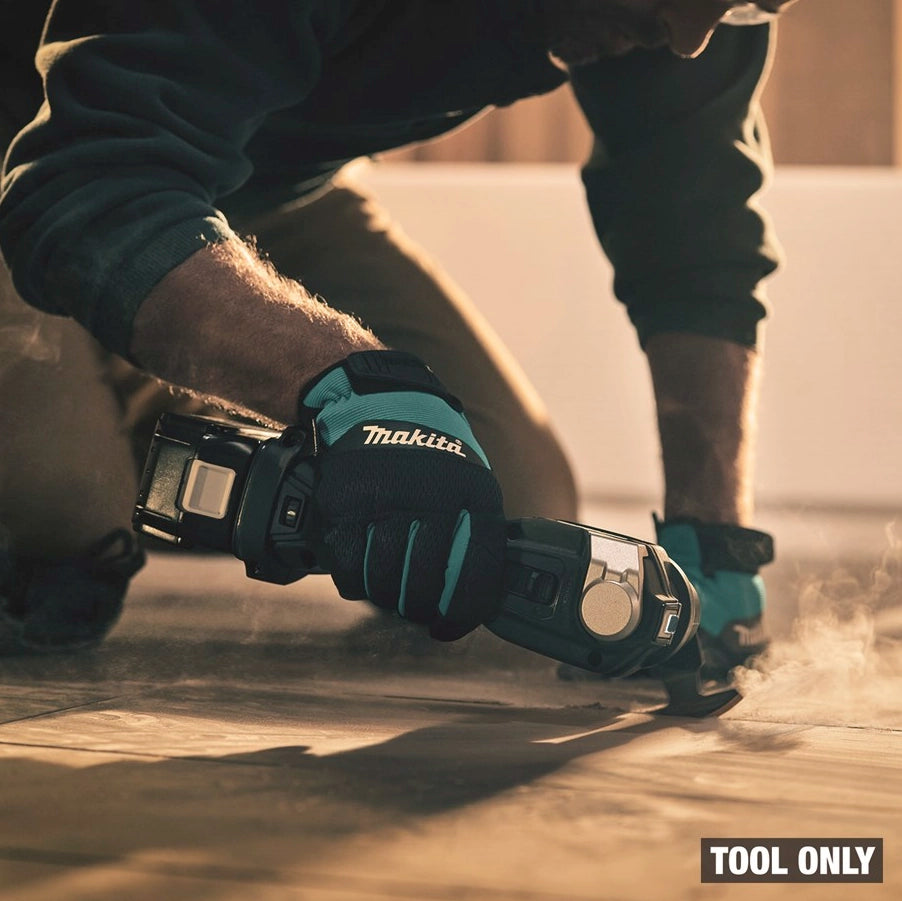 Dust-covered Makita XMT04ZB actively working on tile surface
