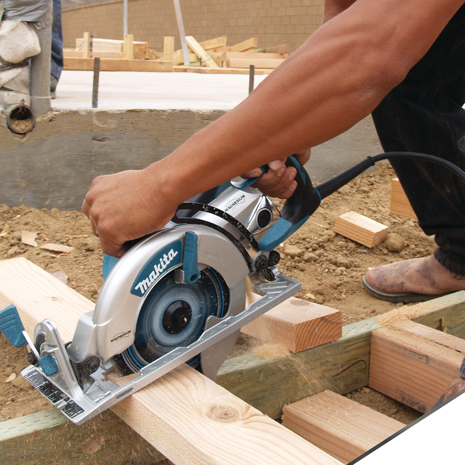 Makita Hypoid Saw cutting through thick wood plank on job site
