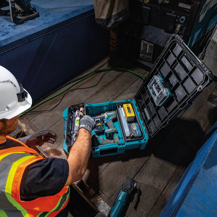 Man working with tools from MAKTRAK™ box inside container truck bed