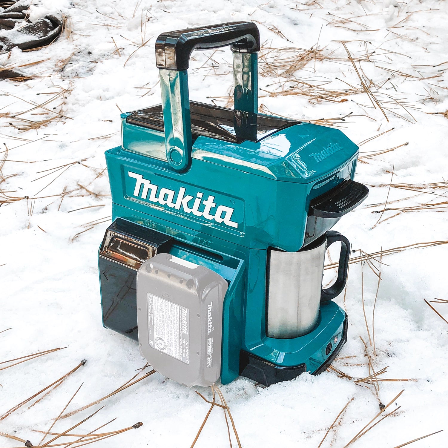 man holding hot mug next to makita coffee maker on outdoor job site
